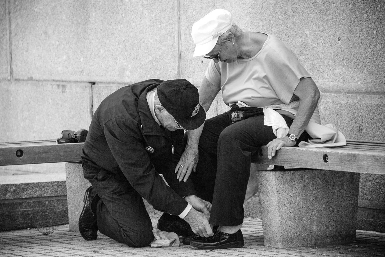 Elder Man Helping Elder Woman to Tie Her Shoes